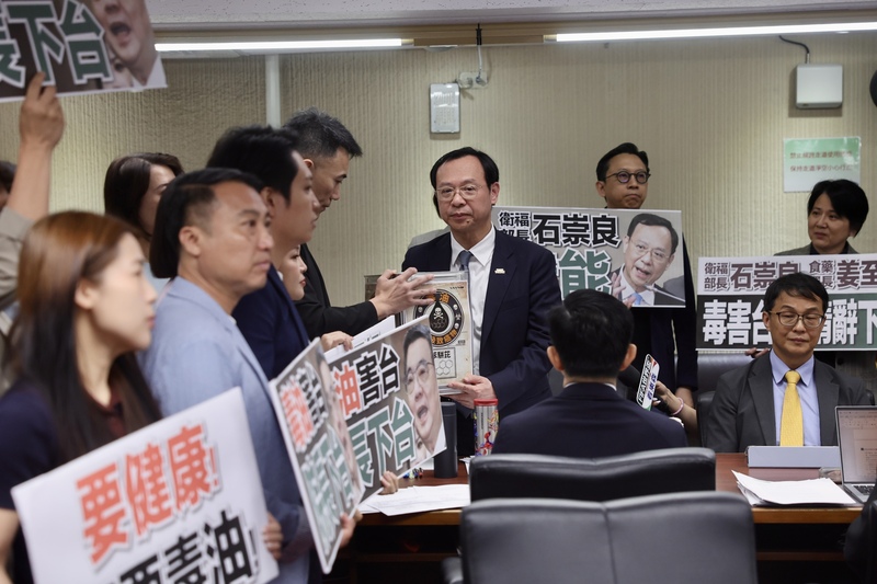 立法院社福及衛環委員會8日邀衛福部長石崇良等專題報告「食安問題爆不停，如何構建使國人安心生活、就學與食品廠安全管理精進作為」並備質詢，在野黨立委群起要求官員下台負責，並將象徵毒油的沙拉油桶交給衛福部長石崇良（中右）。
