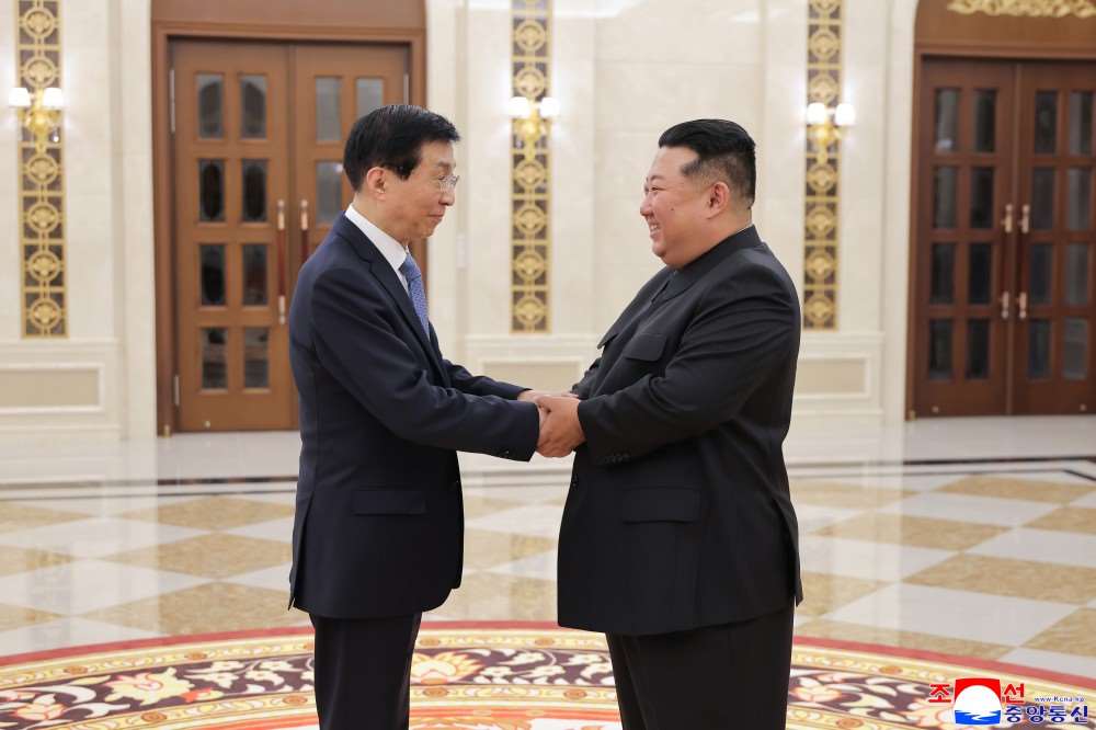 北韓領導人金正恩16日在平壤會見到訪的中共中央政治局常委王滬寧。(圖:KCNA)