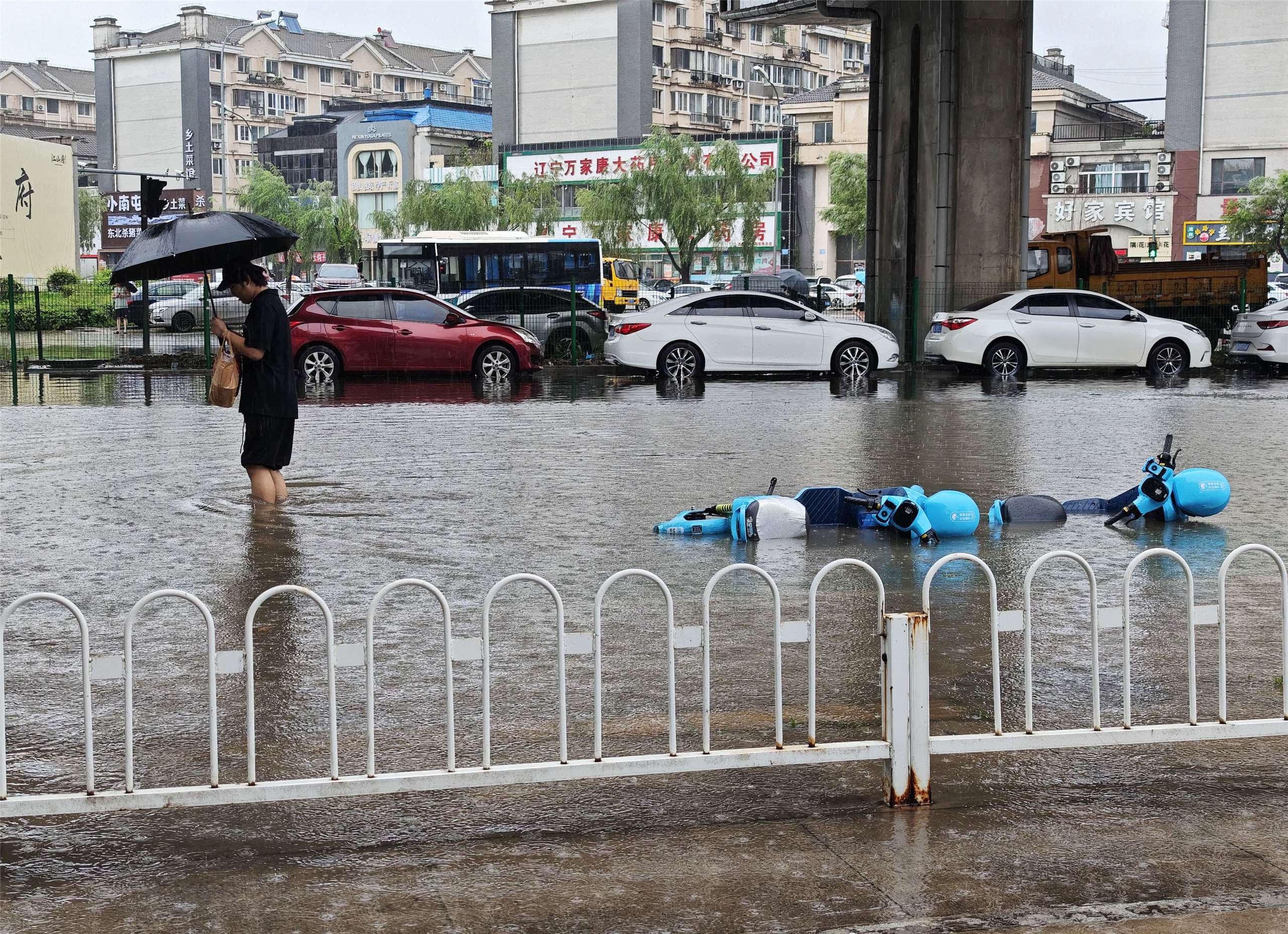 7月12日20時至13日11時，遼寧省中北部地區出現暴雨到大暴雨，瀋陽地區局部出現特大暴雨。圖為瀋陽一名男子在積水的路面行走。