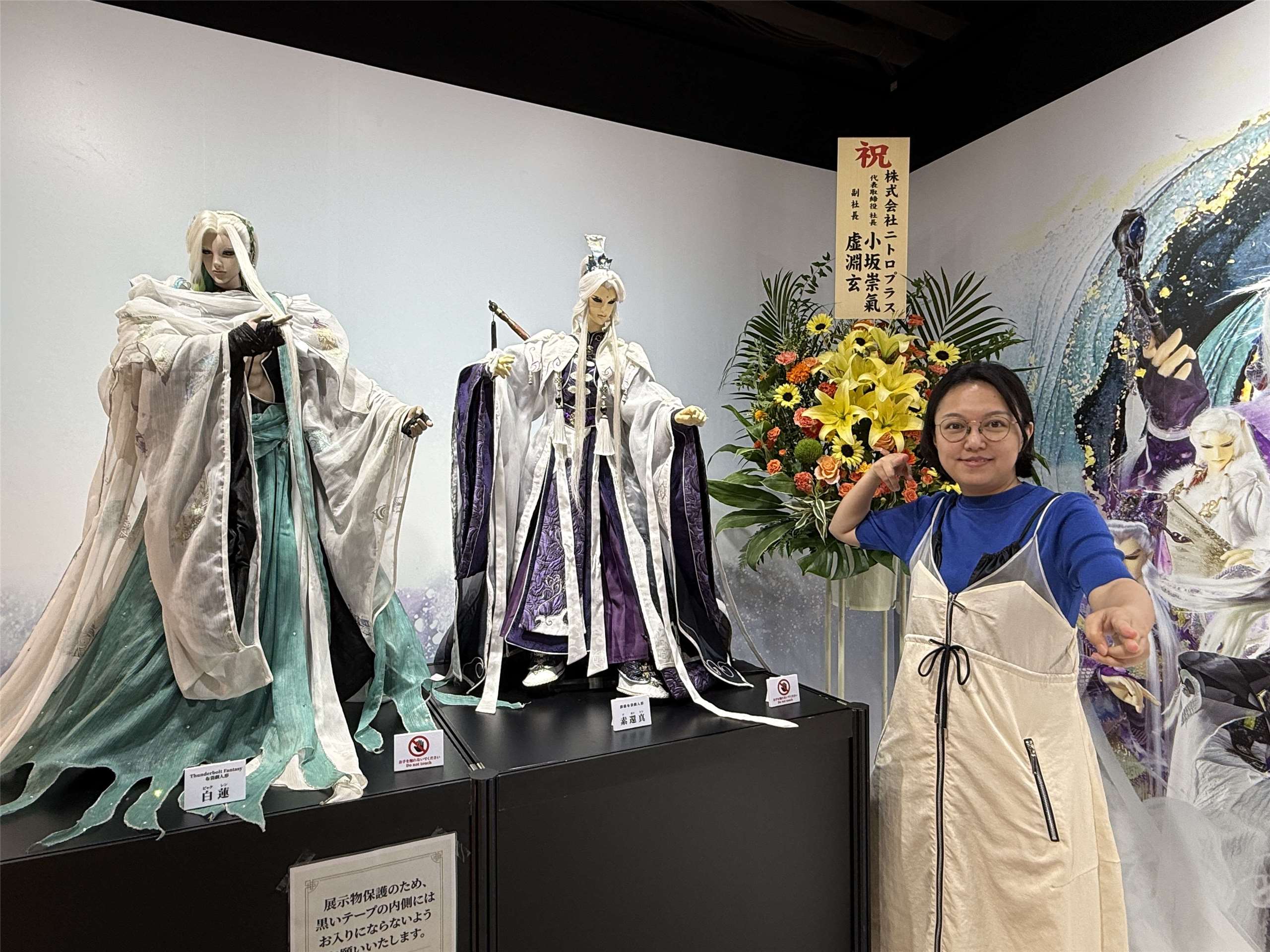 站在展覽會場前的素還真跟白蓮布偶前擺出同樣姿勢的霹靂國際多媒體品牌總監黃政嘉。(鄭仲嵐攝影)