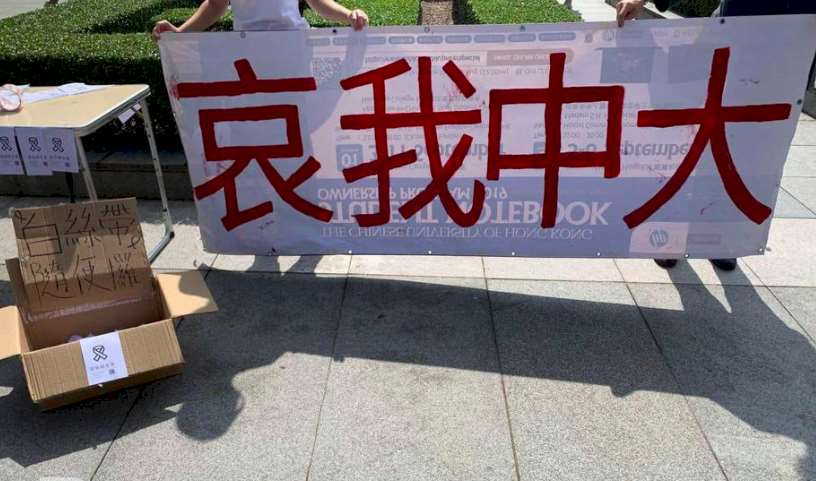 當文明法規成為權貴的護身符，而平民與學生卻動輒遭誅心懲戒、行政打壓，香港中文大學恐已背離創校精神。示意圖為資料照，中大畢業生在校園掛起「哀我中大」白布條，並以白絲帶哀悼學生自治之死。(資料照/立場新聞提供)