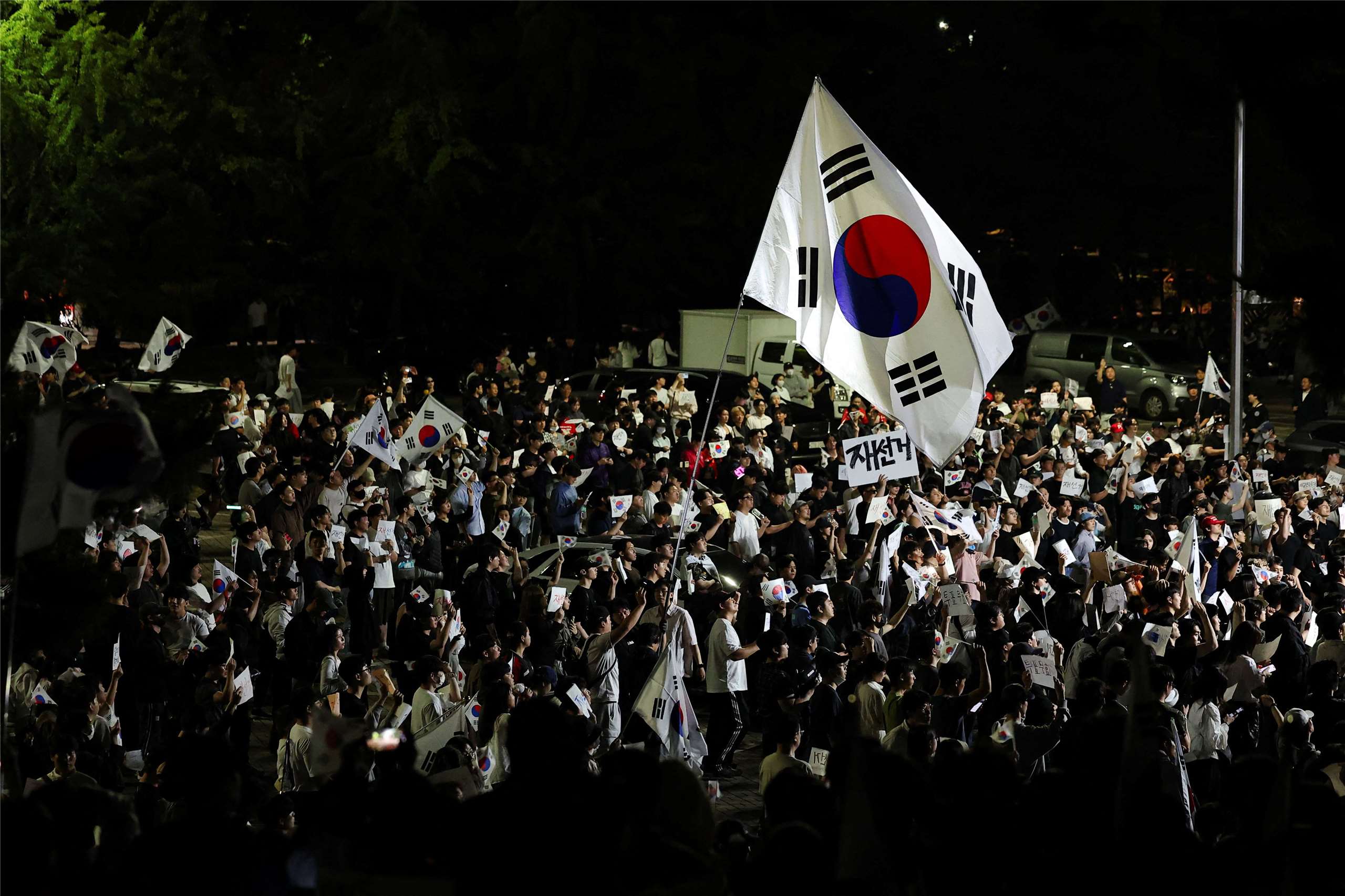 圖為2026年6月6日，南韓抗議群眾包圍首爾一處計票中心，抗議因選票短缺引發的爭議，並呼籲重新舉行地方選舉。資料照片。