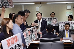 立法院社福及衛環委員會8日邀衛福部長石崇良等專題報告「食安問題爆不停，如何構建使國人安心生活、就學與食品廠安全管理精進作為」並備質詢，在野黨立委群起要求官員下台負責，並將象徵毒油的沙拉油桶交給衛福部長石崇良（中右）。