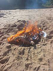 金門縣金湖鎮新頭岸際日前發現1隻海漂死亡豬屍，檢出非洲豬瘟病毒核酸陽性。圖為金門縣動植物防疫所人員赴現場執行檢體採樣及消毒作業後，就地焚化掩埋豬屍。（金門縣政府提供）