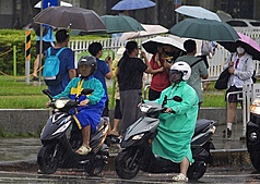 中央氣象署17日指出，未來一週天氣炎熱，南部地區不定時有陣雨或雷雨，需防較大雨勢。圖為高雄市前鎮區17日午後出現降雨，街頭騎士雨中停等。