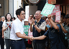 民進黨台北市長參選人沈伯洋（前左）18日上午前往直興市場拜票，獲得不少民眾歡迎，現場「凍蒜」聲不斷。