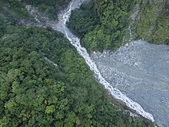 萬里溪堰塞湖維持穩定溢流，農業部有條件開放河道灌溉取水，但仍實施24小時紅色警戒管制。圖為22日下午空拍畫面。(林保署花蓮分署提供)
