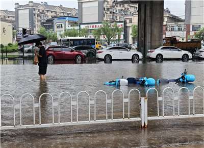 7月12日20時至13日11時，遼寧省中北部地區出現暴雨到大暴雨，瀋陽地區局部出現特大暴雨。圖為瀋陽一名男子在積水的路面行走。