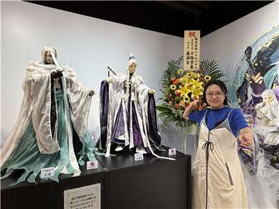 站在展覽會場前的素還真跟白蓮布偶前擺出同樣姿勢的霹靂國際多媒體品牌總監黃政嘉。(鄭仲嵐攝影)