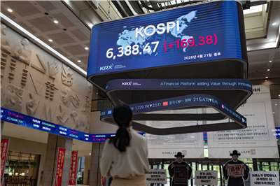 受惠AI股回溫，韓國綜合股價指數今(31)日收盤跳漲近18%，創單日最大漲幅。圖為韓國首爾的韓國證券交易所(KRX)，一名員工觀看顯示韓國綜合股價指數(KOSPI)的電子看板。資料照片(AFP)