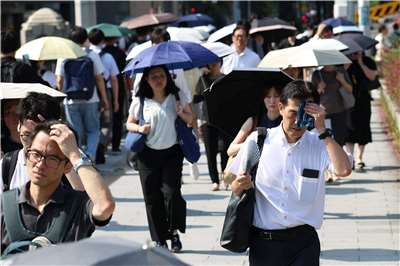 日本熱浪來襲，在大阪市區，有人揮汗如雨，有人忙著撑陽傘抵擋陽光照射。