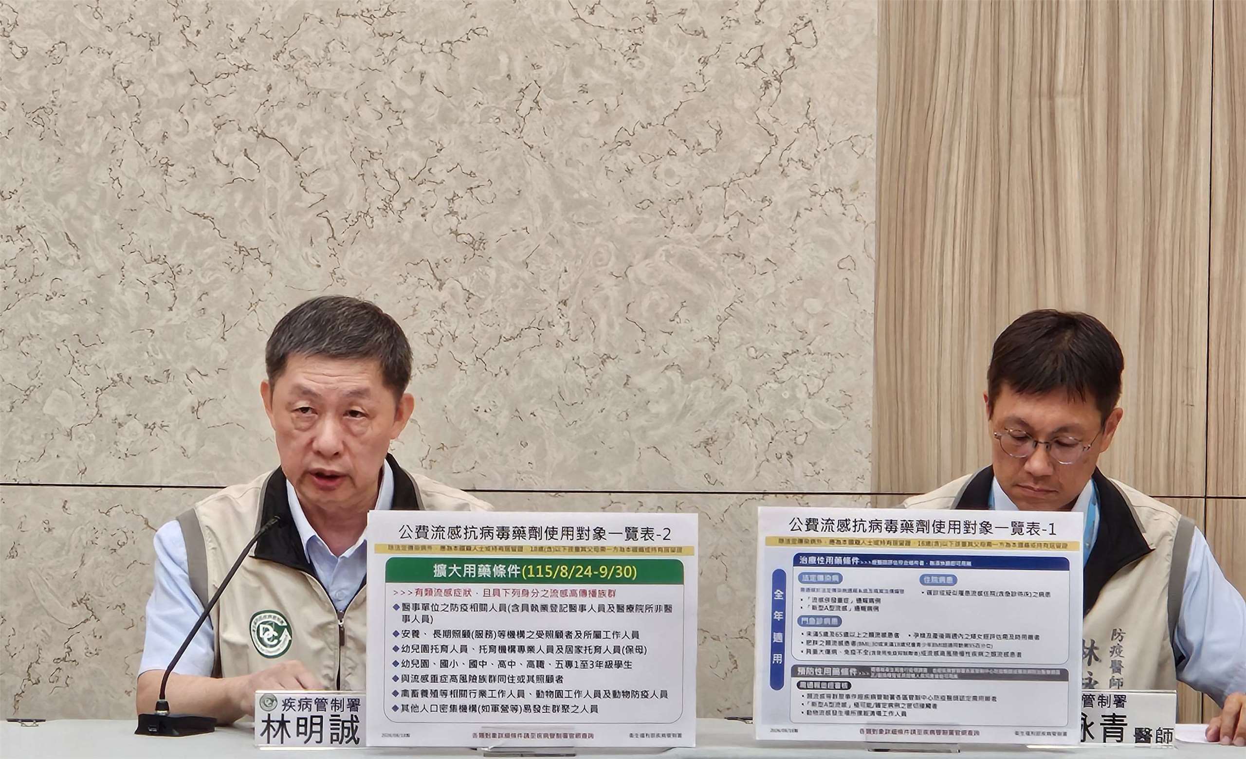 疾管署發言人林明誠(左)宣佈自8/24起至9/30擴大公費流感抗病毒藥劑使用條件。(劉品希 攝)