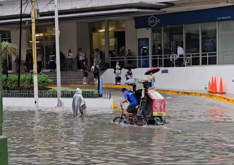 菲律賓正值雨季，大馬尼拉地區多處因豪雨而淹水，鉤端螺旋體病感染風險隨之升高。圖為在馬卡蒂市（Makati），有三輪車及民眾涉水而過。