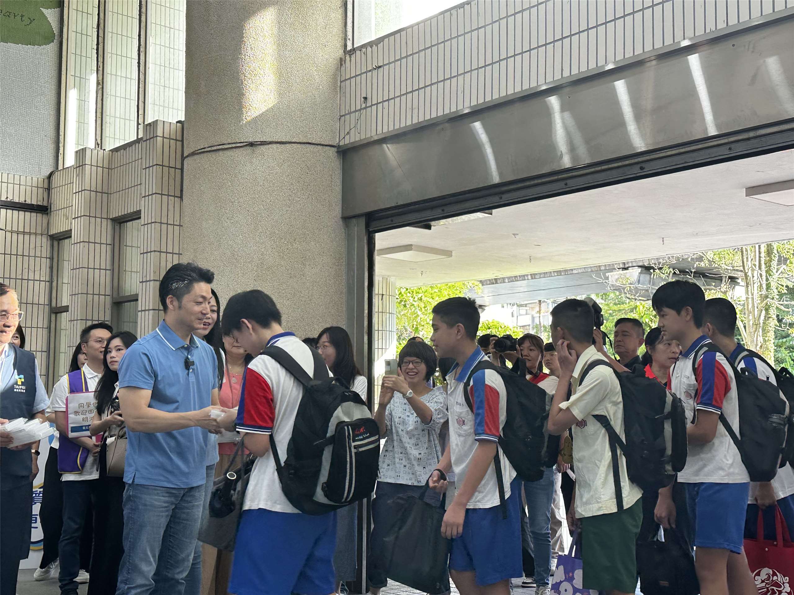 台北市長蔣萬安(左一)在31日開學日當天一早，前往台北市明湖國中歡迎同學上學，也說明自己推出的生生喝鮮奶3.0政策。(楊雨青攝)