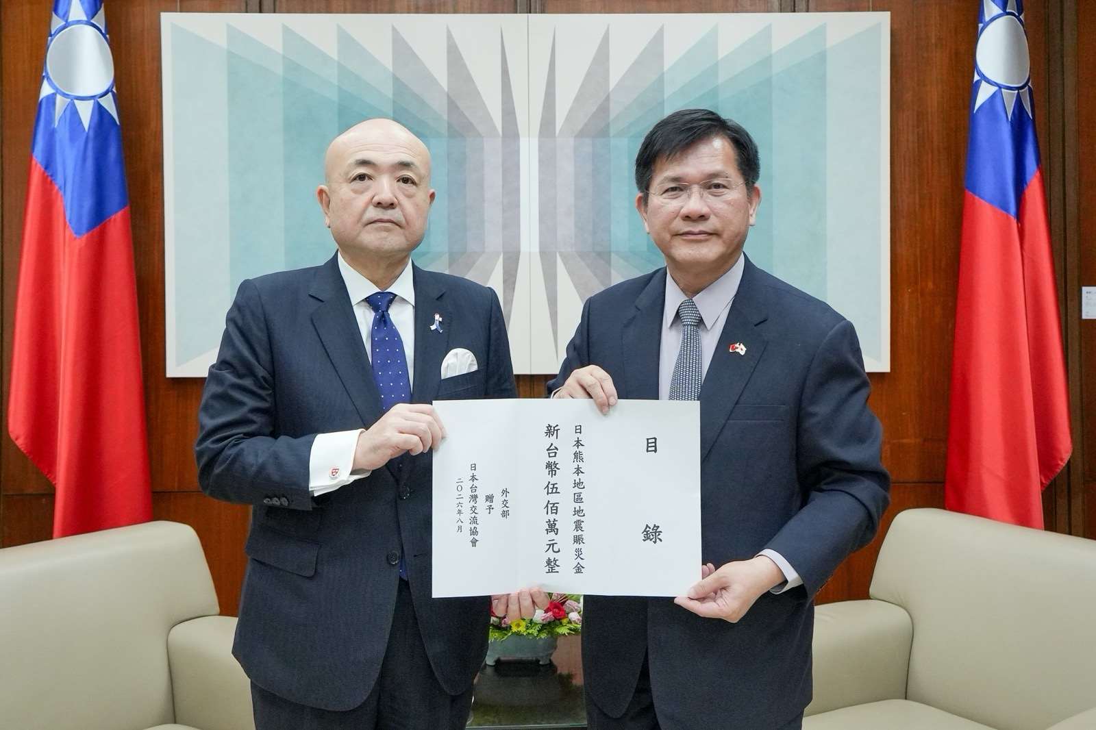 外交部長林佳龍（右）向日台交流協會代表片山和之（左）遞交新台幣500萬元賑災款。(外交部)