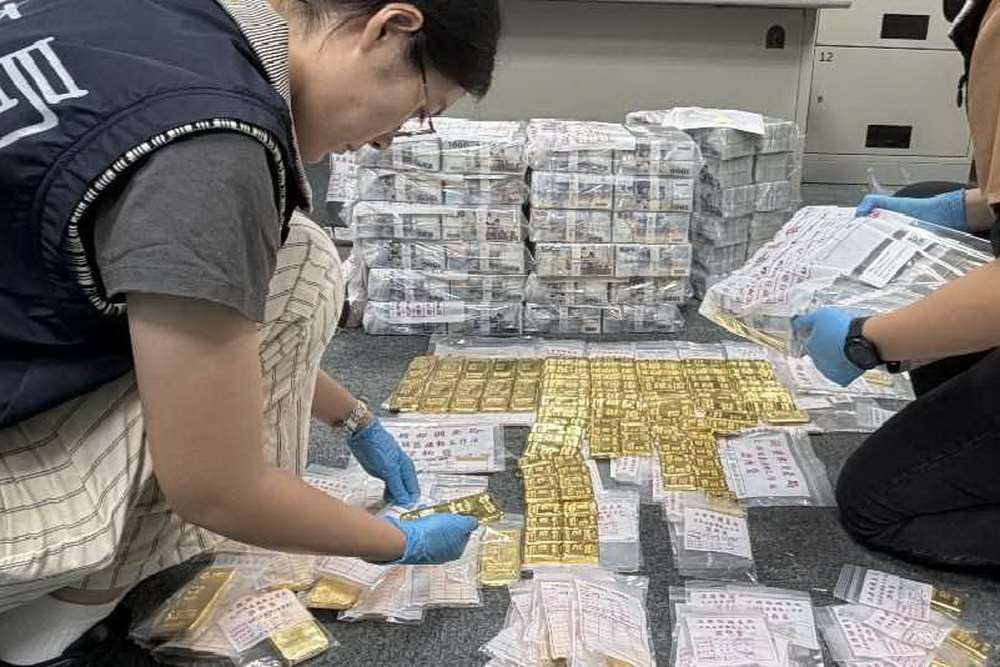 彰化律師公會前理事長陳昱瑄等人遭控於疫情期間詐取疫苗採購委任報酬，圖為檢警與調查局人員搜索查扣大量黃金條塊與現鈔。(台中地檢署提供)