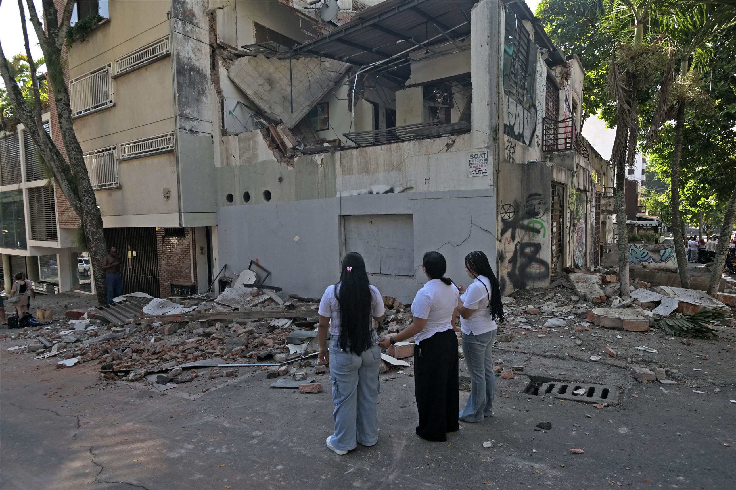 哥倫比亞10日發生重大地震。圖為卡利民眾凝視受損建築物。