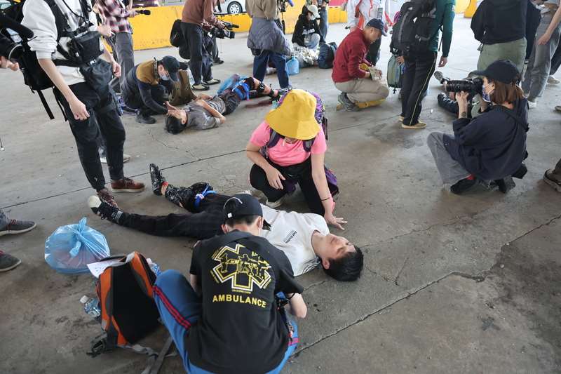 面對中國的軍事威嚇與認知戰，紐時報導台灣快速成長的民防訓練，從學習求生技能到反制假訊息，試圖構築堅實的平民防線。圖為黑熊學院第5屆「藍鵲行動」戶外大型演訓在台北市大佳河濱公園演練大量傷患救護。(資料照片/中央社)