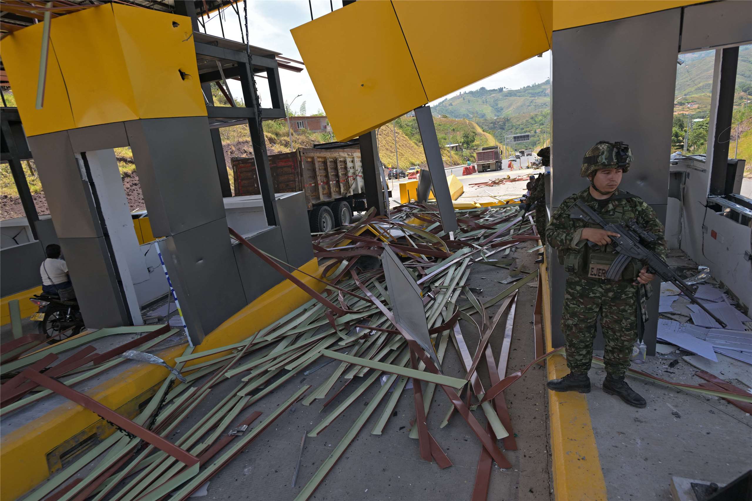 哥倫比亞軍方表示，「哥倫比亞革命軍」(FARC)的游擊隊異議分子，用炸藥炸毀了卡利附近的一個高速公路收費站。圖為遭到襲擊後，一名士兵在站崗。
