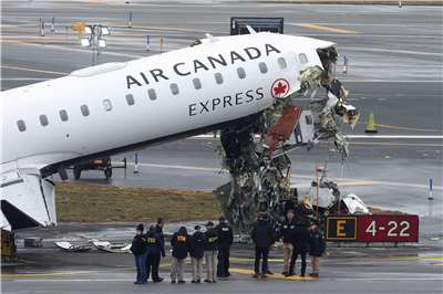 紐約拉瓜迪亞機場今年3月間一架加拿大航空快捷公司貨機與消防車相撞，圖為安全人員正在檢視事故後的殘骸。(路透社/達志影像)