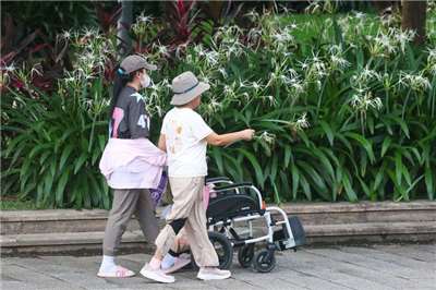 圖為外籍幫傭與雇主一同散步。資料照。