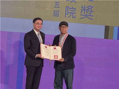 電影剪接大師廖慶松(右)5日從行政院長卓榮泰(左)手中接下行政院文化獎殊榮。(江昭倫 攝)