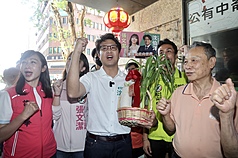 民進黨台北市長參選人沈伯洋（中）1日前往中崙市場掃街拜票。