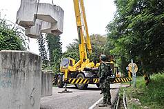 國軍漢光42號實兵演習第2天，陸軍金門防衛指揮部6日於金湖鎮交通要道依計畫執行聯外道路阻絕架設，先制預應縱深防禦。圖為軍方徵用民間吊車吊掛消波塊置放。（金防部提供）