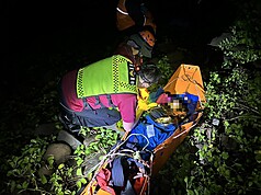 屏東滿州鄉欖仁溪發生虎頭蜂攻擊事件，警消獲報馳援，因路途遙遠、地形崎嶇陡峭，當地又下起大雨，在救援難度極為困難下，搜救人員透過輪流搬運，15日清晨4時許順利將受傷女子送醫救治，另仍2名男子失聯搜救中。（屏東消防局提供）