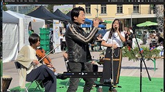 駐芬蘭代表林昶佐（中）與台灣杉樂團主唱Kiwa（右，身穿布農族傳統族服）在「亞洲設計文化節」舞台上合唱，向國際友人展現台灣文化魅力。