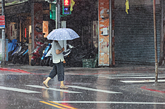 中央氣象署表示，23日南部地區有局部豪雨等級以上降雨發生的機率，低窪地區請慎防積淹水。圖為民眾撐傘過馬路。資料照。