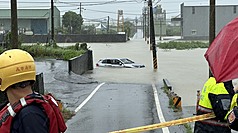 高雄豪雨不斷，23日鳥松區一輛汽車因行經積淹水路段幾乎遭滅頂，車內3人逃出車外呼救，幸無人受傷。（高雄市消防局提供）