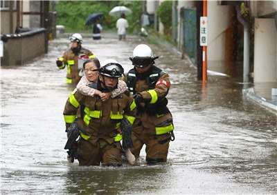 日本石川縣、富山縣27日豪雨成災，圖為消防員協助石川縣羽咋市的長者撤離。