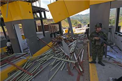 哥倫比亞軍方表示，「哥倫比亞革命軍」(FARC)的游擊隊異議分子，用炸藥炸毀了卡利附近的一個高速公路收費站。圖為遭到襲擊後，一名士兵在站崗。