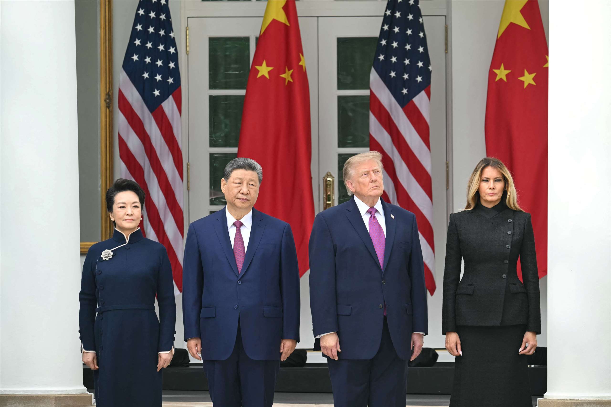 中國第一夫人彭麗媛(左一)、中國國家主席習近平(左二)、美國總統川普(右二)和美國第一夫人梅蘭妮亞(右)在華盛頓白宮玫瑰園觀看閱兵式。(AFP)