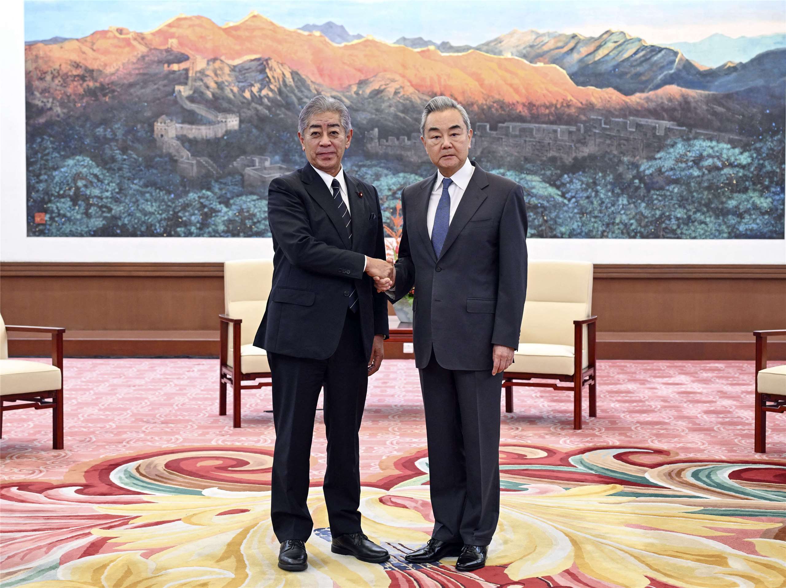 中國外交部長王毅(右)28日在北京會晤日本前外務大臣岩屋毅。(新華社)