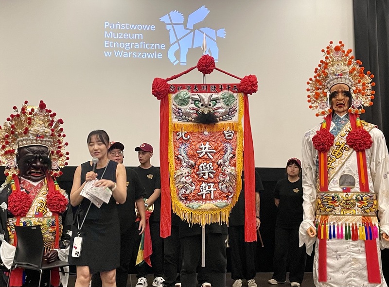 台北共樂軒在與華沙波蘭國家民俗博物館的交流會上，展示陣頭前導的精美「頭旗」，上面特別刺有「丙午年歐洲表演紀念」字樣，紀錄此趟交流之旅。