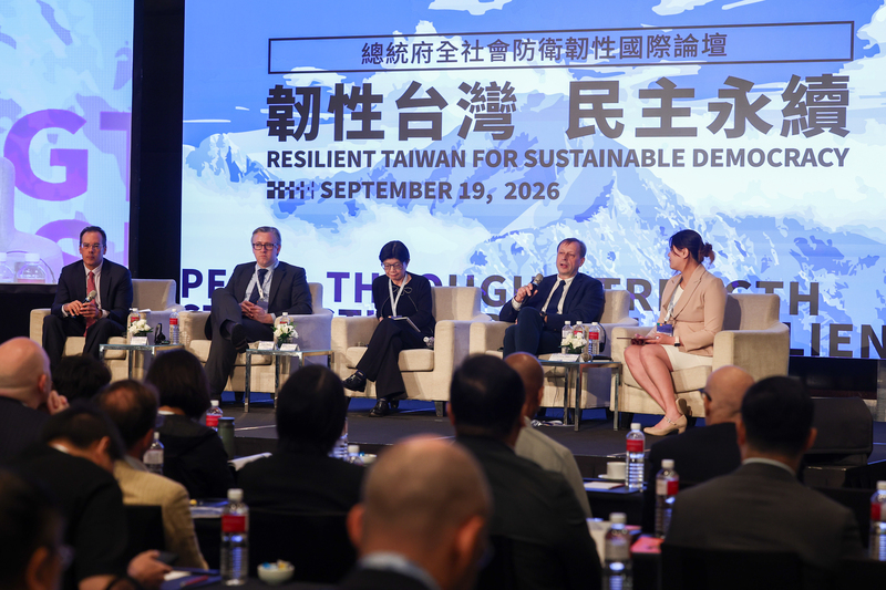 2026總統府全社會防衛韌性國際論壇19日在台北舉行，北約戰略溝通卓越中心資深政策與出版物經理卡爾斯伯斯（後排右2）等嘉賓參與「心理防衛」議題討論，分享觀點。