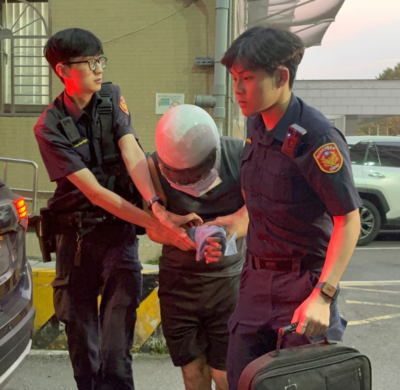 新北市三重區有女童身掛不雅字眼紙板，被家人帶著遊街。警方查獲女童父親（中）涉違反保護令，當場逮捕。29日傍晚移送新北地檢署，檢方複訊後聲押禁見。