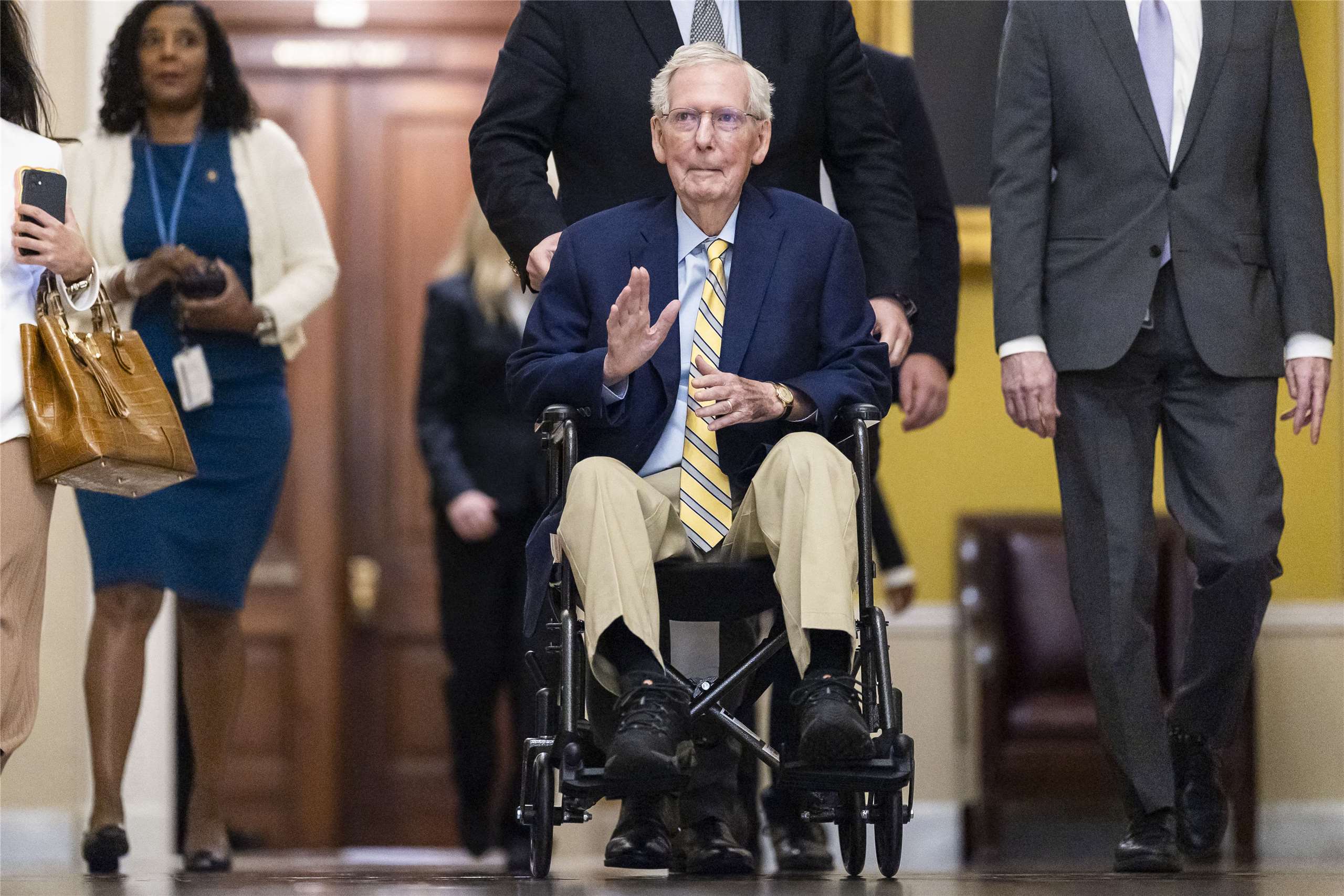 美國共和黨籍參議員麥康奈（Mitch McConnell）(中)14日坐著輪椅重返國會大廳，健康狀態引發關注。