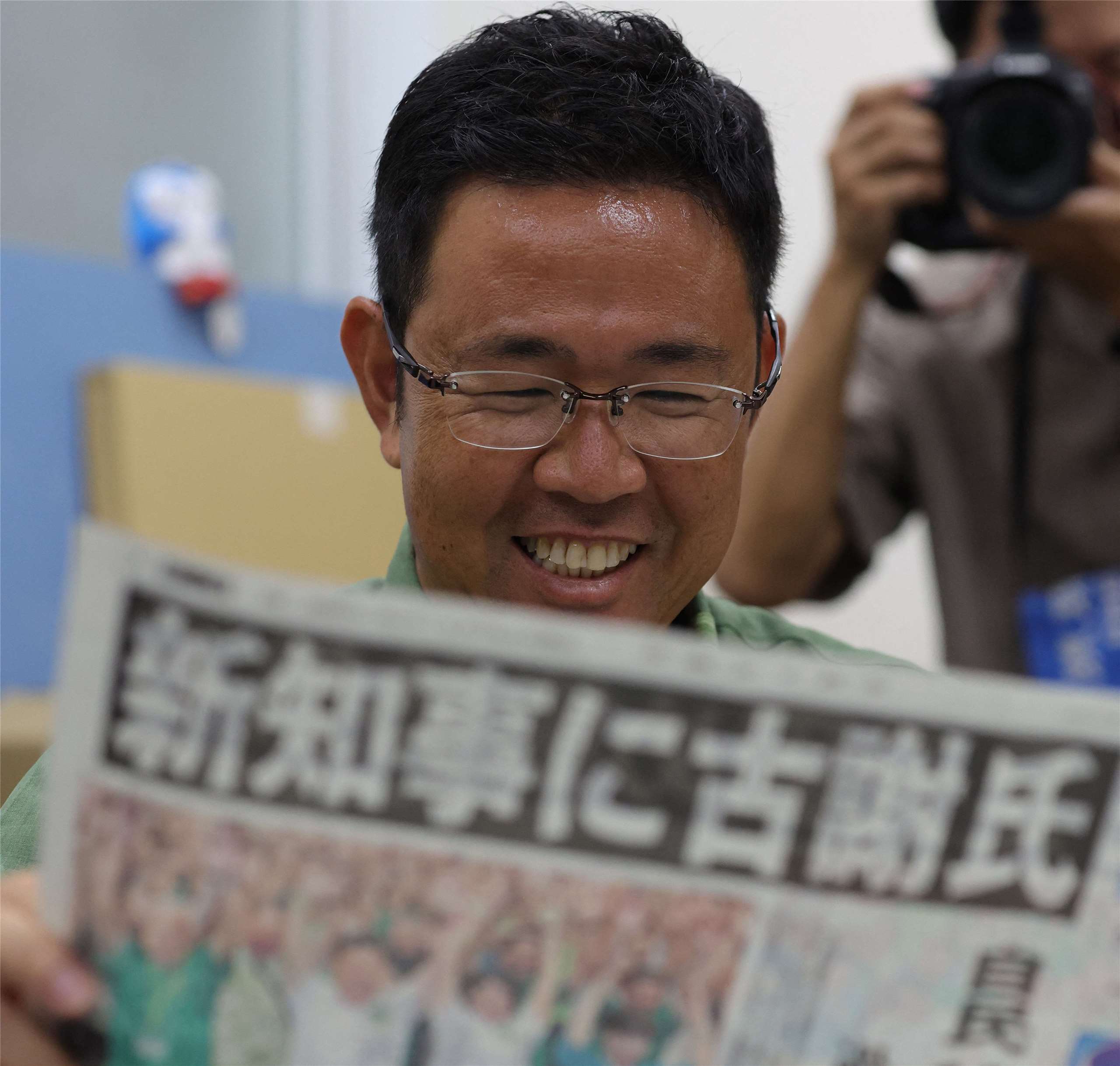 贏得沖繩縣知事選舉的前那霸市副市長古謝玄太正在閱讀他贏得沖繩縣知事選舉的消息。(AFP)