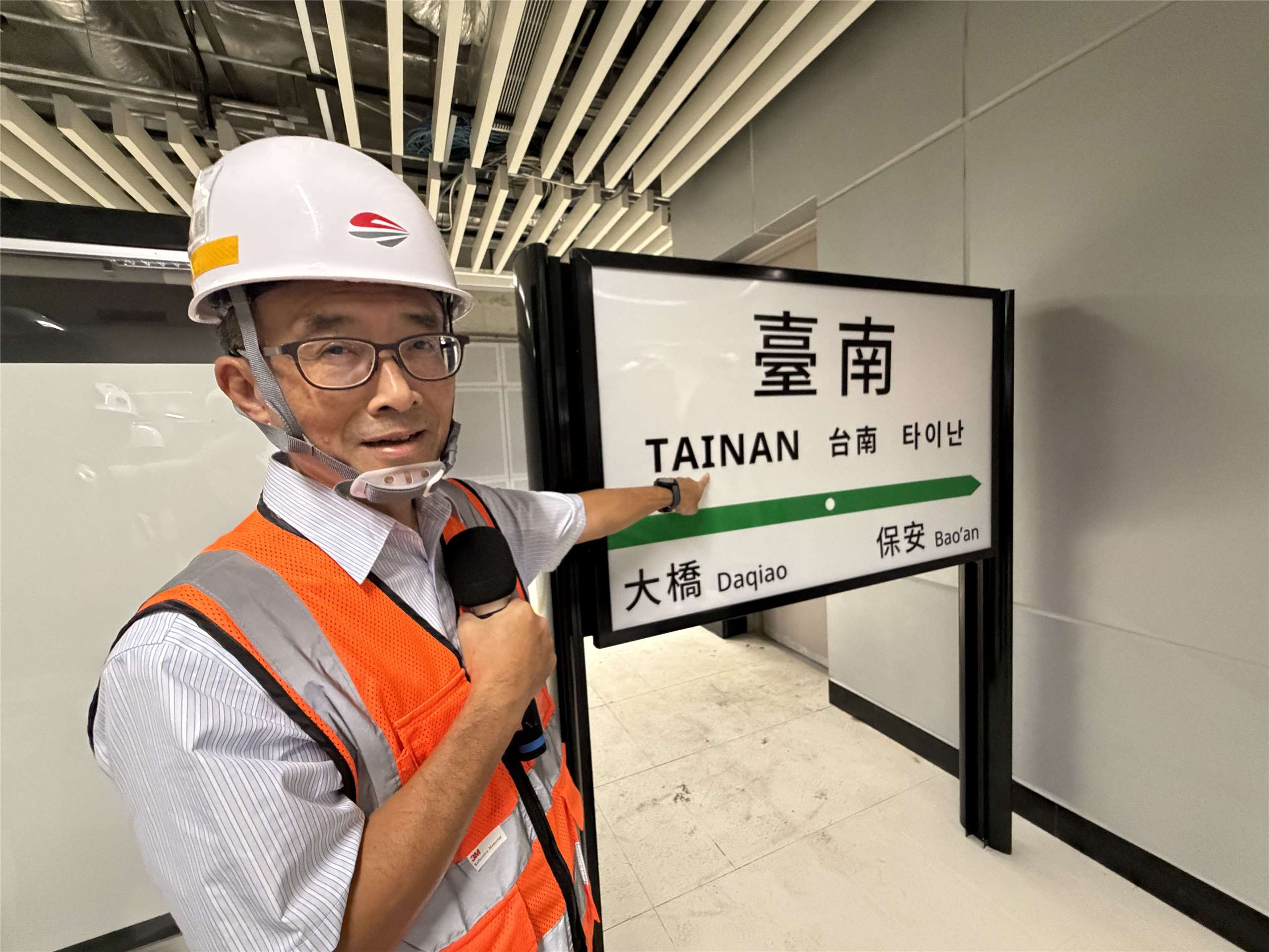 鐵道局南工局長史春華指著台南新站月台上的標示，除了同時引進中、英、日、韓4國語言，就連台南站的英文TAINAN都蘊藏了以「鐵軌斷面」來替代字母「I」的巧思。(吳琍君攝)