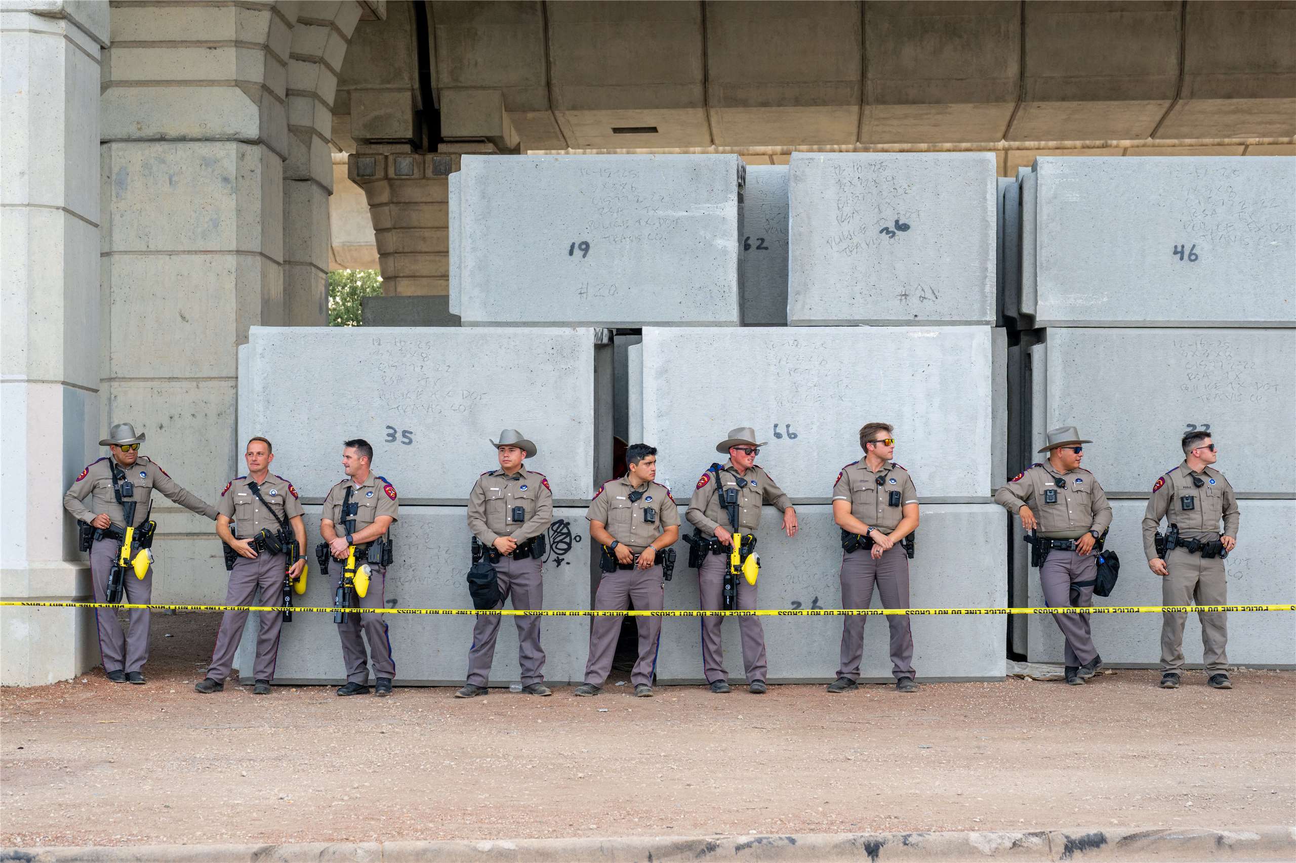 一名美國移民暨海關執法局(ICE)人員20日在德州奧斯汀(Austin)開槍，導致1名男子身受重傷，引發民眾上街抗議。面對示威，執法人員站成一排，嚴陣以待。