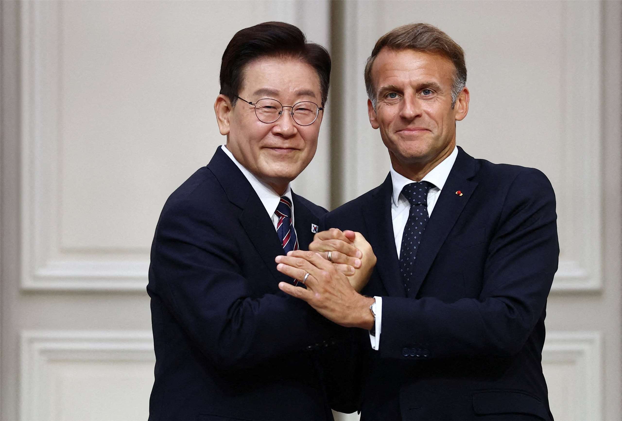 法國總統馬克宏(右)與南韓總統李在明8日在巴黎舉行聯合記者會，李在明表示雙方就國際安全議題交換意見，包括荷莫茲海峽情勢。