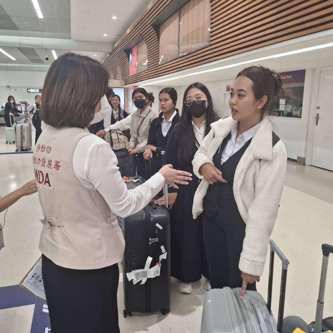 勞動部勞動力發展署機場服務站人員協助引導接機來台的旅宿外國技術人力。(勞動部提供)