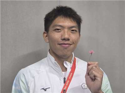 名古屋亞運男子400公尺跨欄銅牌得主林仲威，手中拿著日本志工阿嬤親手送的小花。林仲威表示，這份賽前祝福讓他感到「心裡暖暖的」。（江昭倫  攝）