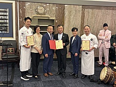 大華府地區僑界團體在美國國會山莊舉行台灣美食文化展，主廚張克勤（左起）、巴城中文學校董事長暨台灣華語文學習中心負責人白越珠、馬里蘭州參議員林力圖、十鼓文化訪團團長邱太三、駐美副代表楊懿珊及主廚路凱源等在活動中合影。
