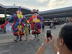 中秋連假第2天各地多雲到晴，大台北地區26日也是晴朗好天氣，有民眾趁著假日走訪台北花博圓山公
園，與表演者開心互動合影。