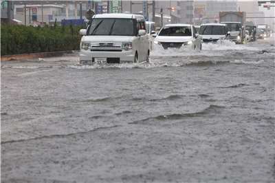 亞運東道主愛知縣名古屋8日晚間遭遇破紀錄暴雨，約400名亞運選手一度被迫撤離住宿地。圖為8日名古屋市汽車行駛於積水道路。