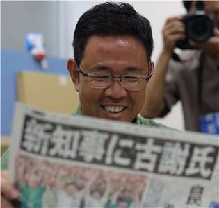 贏得沖繩縣知事選舉的前那霸市副市長古謝玄太正在閱讀他贏得沖繩縣知事選舉的消息。(AFP)